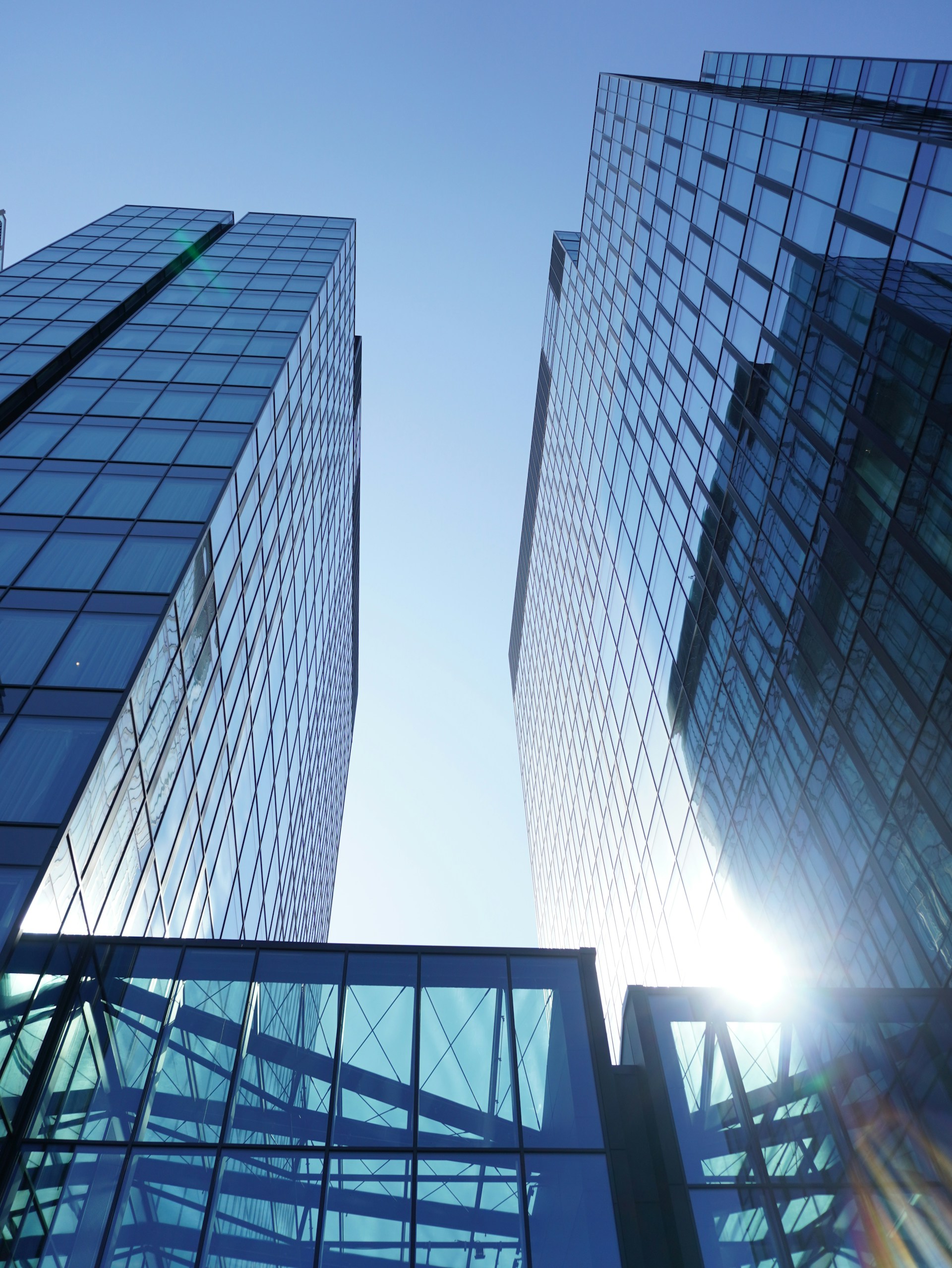 Sunlit glass office towers rising against a clear sky